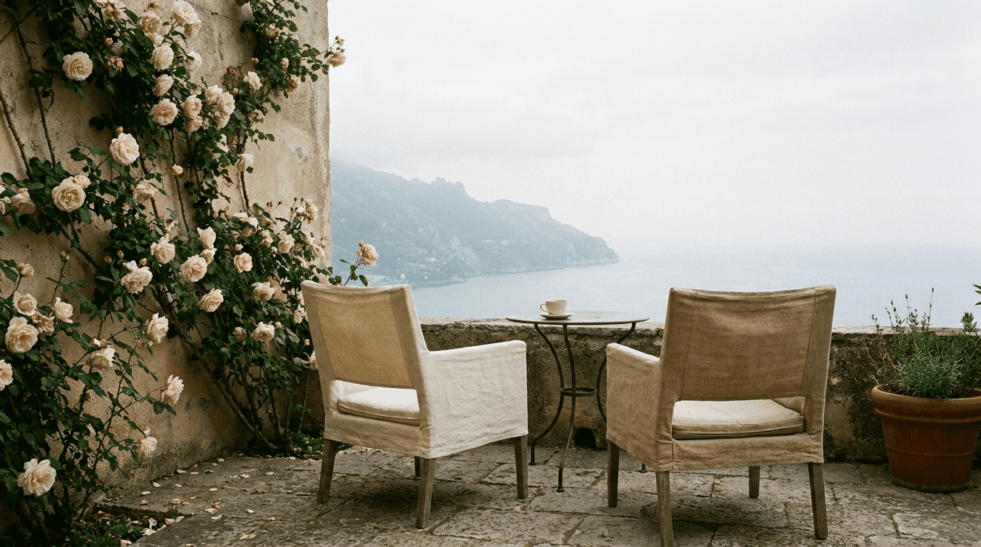 Empty boutique hotel terrace, two chairs facing a Mediterranean view at morning