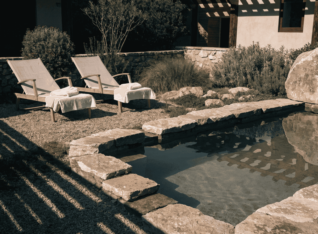 Boutique hotel pool at late afternoon, stone surround, Riviera setting